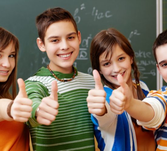 Classmates Portrait of happy teens showing thumbs up