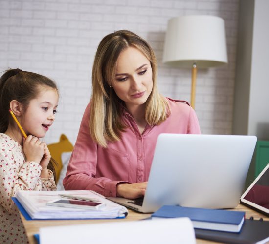 Young mother working from home with daughter Young mother working from home with daughter